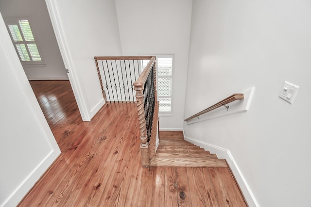 stairs with hardwood / wood-style floors and a wealth of natural light