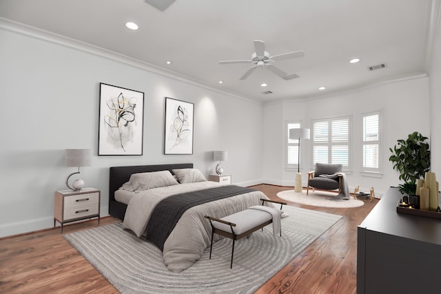 bedroom featuring ceiling fan, hardwood / wood-style flooring, and crown molding