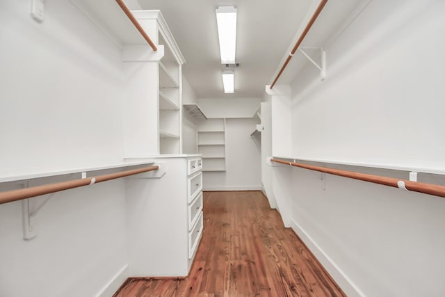 walk in closet with dark hardwood / wood-style floors