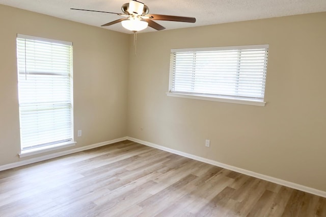 empty room with ceiling fan, light hardwood / wood-style flooring, and plenty of natural light