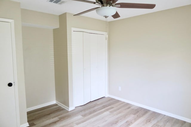 unfurnished bedroom with ceiling fan, light hardwood / wood-style flooring, and a closet