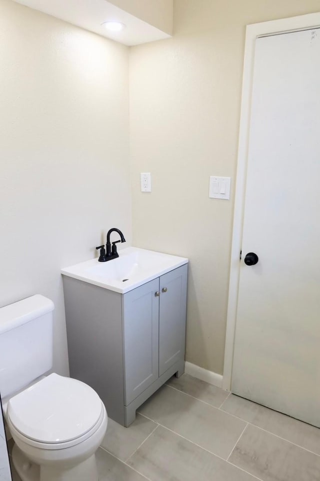 bathroom featuring tile patterned floors, vanity, and toilet