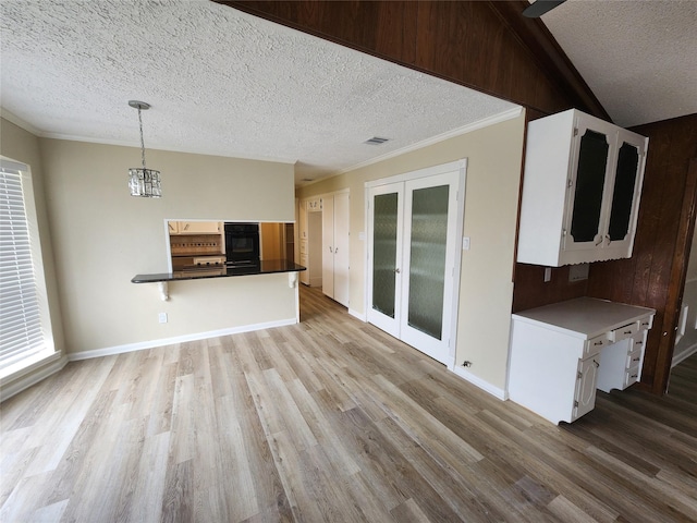 unfurnished living room featuring light wood-type flooring, ornamental molding, a notable chandelier, french doors, and a textured ceiling