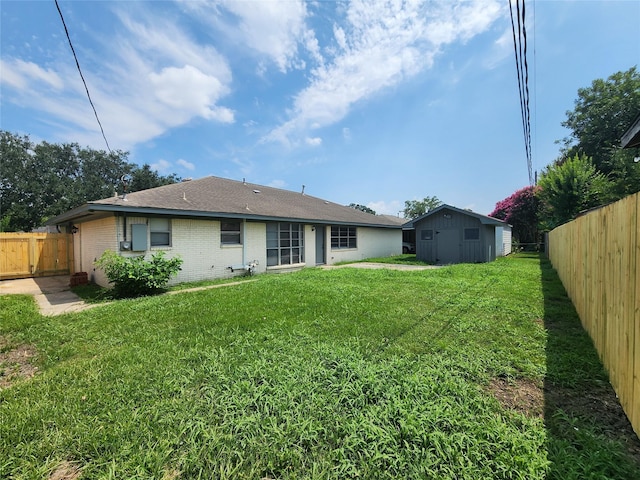 rear view of property with a lawn and a shed