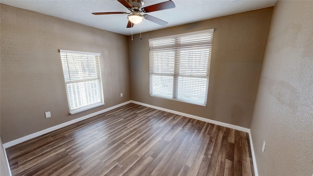 spare room featuring dark hardwood / wood-style flooring, ceiling fan, and a wealth of natural light