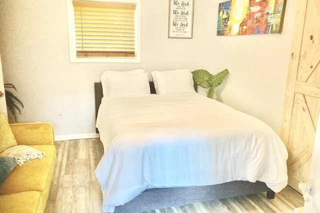 bedroom featuring baseboards and wood finished floors