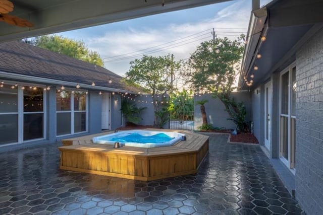 view of pool featuring a ceiling fan, hot tub deck surround, and fence