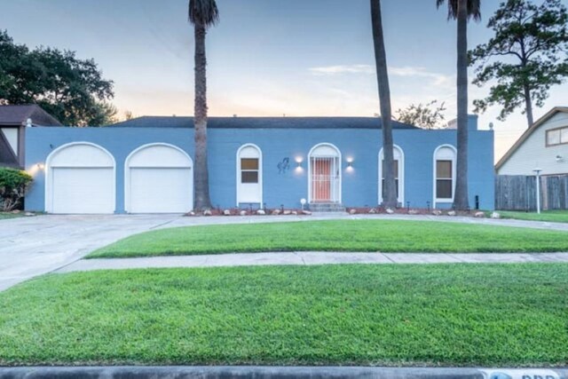 view of front of home featuring a garage, a yard, and driveway