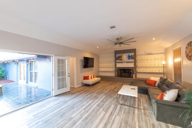 living room featuring ceiling fan, vaulted ceiling, and hardwood / wood-style floors