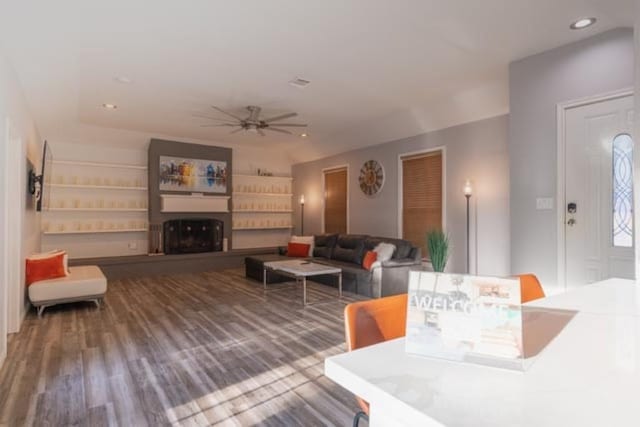 living room with ceiling fan, a fireplace, wood finished floors, and recessed lighting