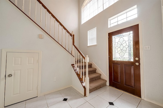 foyer featuring a towering ceiling and light tile patterned floors