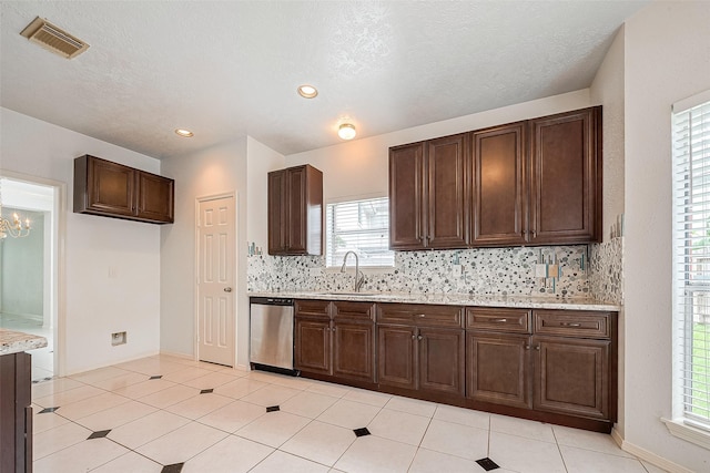 kitchen with sink, light tile patterned floors, stainless steel dishwasher, decorative backsplash, and dark brown cabinets