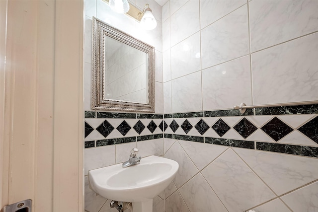 bathroom featuring tile walls and sink