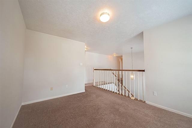 carpeted spare room featuring a textured ceiling