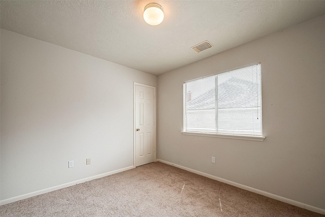 carpeted spare room with a textured ceiling