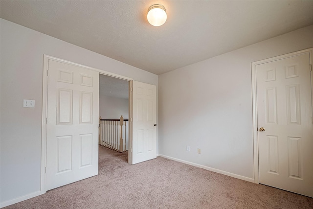 unfurnished bedroom featuring a closet and light carpet