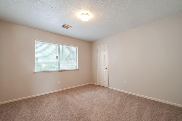 carpeted spare room with a textured ceiling