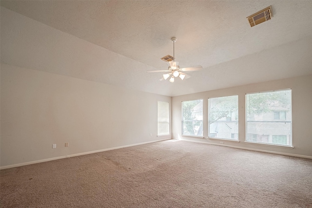 carpeted spare room with ceiling fan, a wealth of natural light, and a textured ceiling