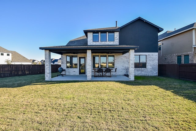 back of property featuring a patio and a yard