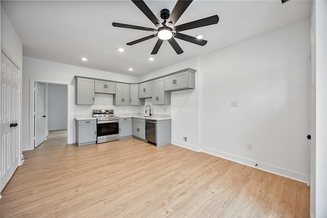 kitchen with ceiling fan, stainless steel appliances, light hardwood / wood-style flooring, and gray cabinets