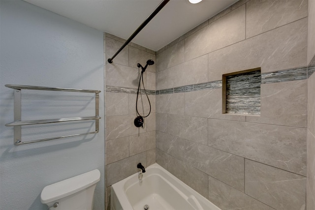 bathroom with tiled shower / bath combo and toilet