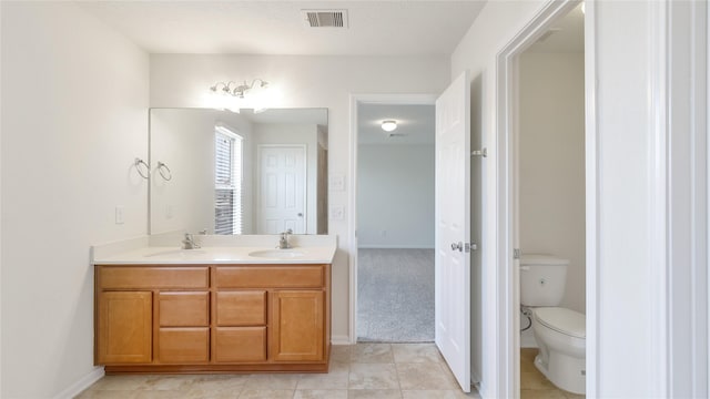 bathroom featuring toilet, tile patterned flooring, and vanity