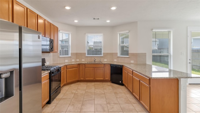 kitchen with black appliances, light stone countertops, kitchen peninsula, and light tile patterned floors