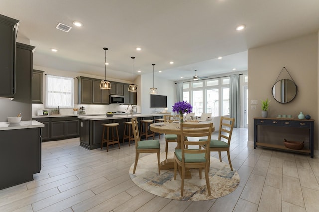 dining space featuring ceiling fan, a healthy amount of sunlight, and sink