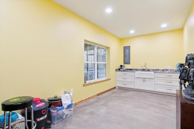 bathroom with electric panel, concrete flooring, and vanity