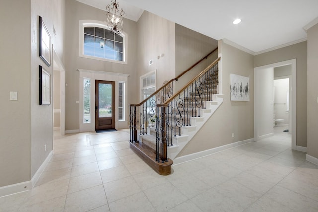 foyer with crown molding and an inviting chandelier