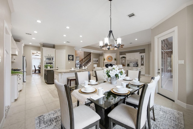 dining room with light tile patterned floors, ornamental molding, and a notable chandelier