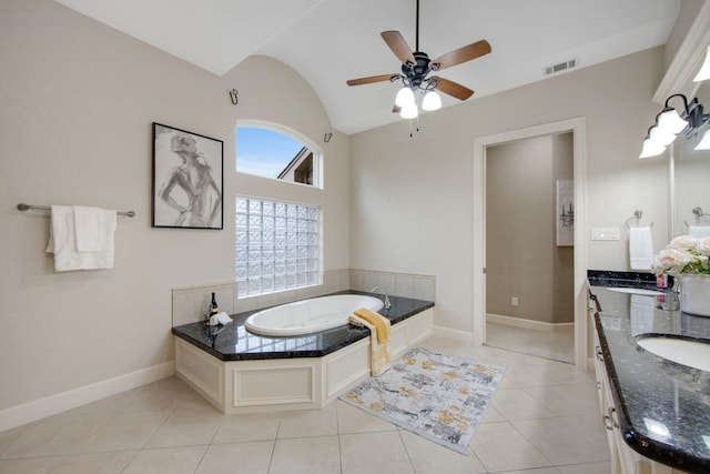 bathroom with ceiling fan, vanity, tile patterned flooring, lofted ceiling, and a tub to relax in