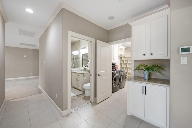 laundry area with crown molding, light carpet, separate washer and dryer, and cabinets