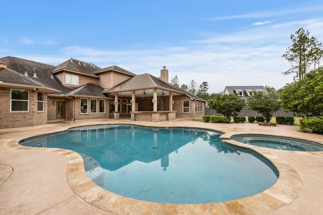 view of pool with a patio area and an in ground hot tub