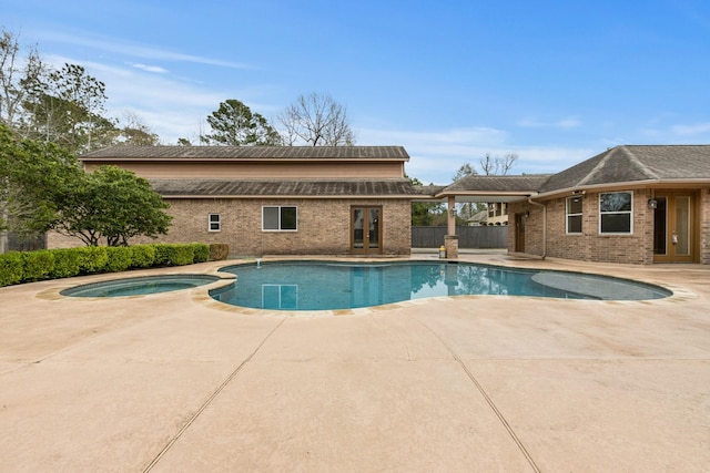 view of pool featuring a patio area and an in ground hot tub