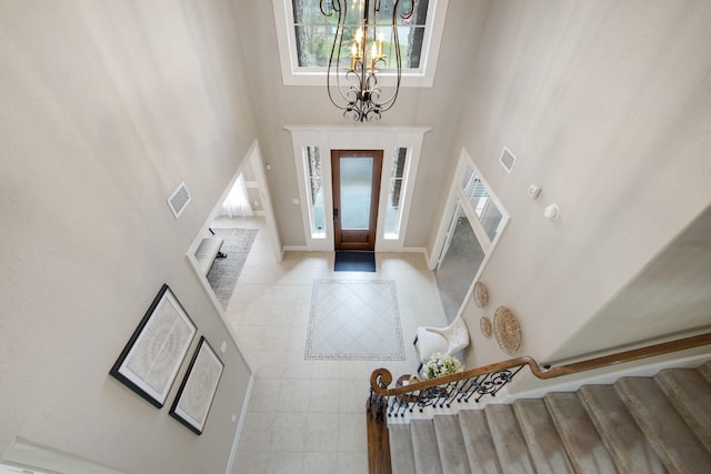 foyer entrance featuring a towering ceiling and a notable chandelier