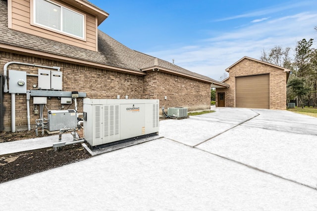 view of side of home featuring central AC unit, an outdoor structure, and a garage