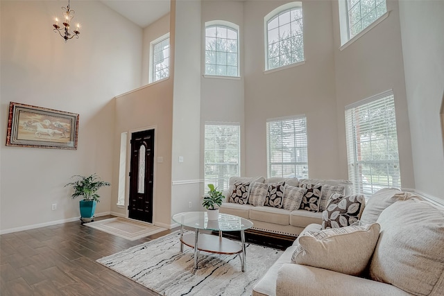 living room with a towering ceiling and a chandelier