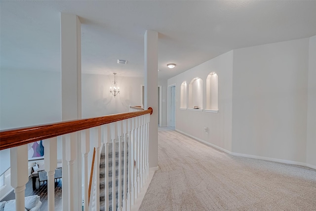 hall with a notable chandelier and carpet flooring