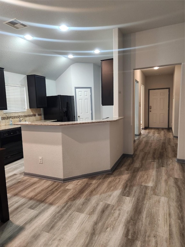 kitchen with sink, hardwood / wood-style flooring, black appliances, and kitchen peninsula