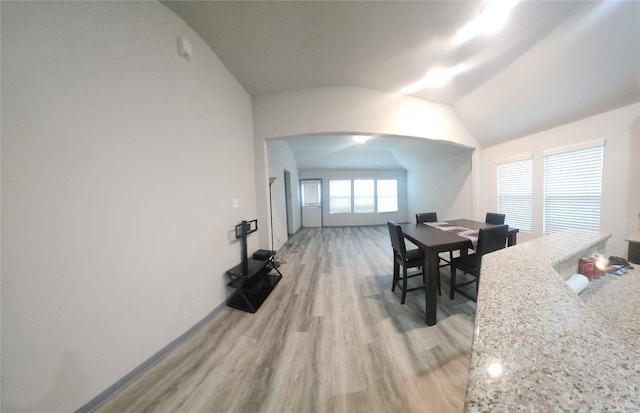 dining area featuring lofted ceiling and light hardwood / wood-style flooring