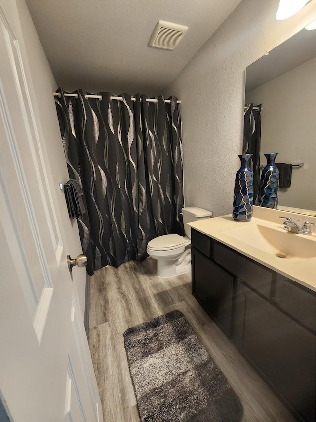 bathroom featuring vanity, toilet, and hardwood / wood-style floors