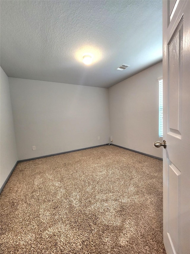 unfurnished room featuring carpet flooring and a textured ceiling