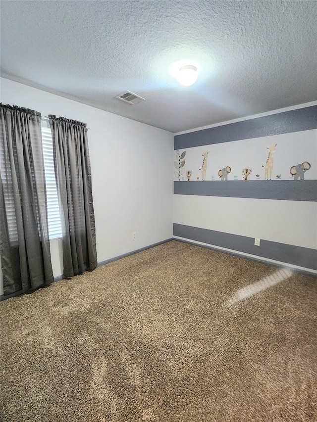 carpeted spare room featuring a textured ceiling