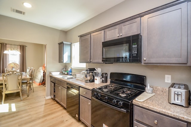 kitchen featuring light hardwood / wood-style floors, black appliances, and sink