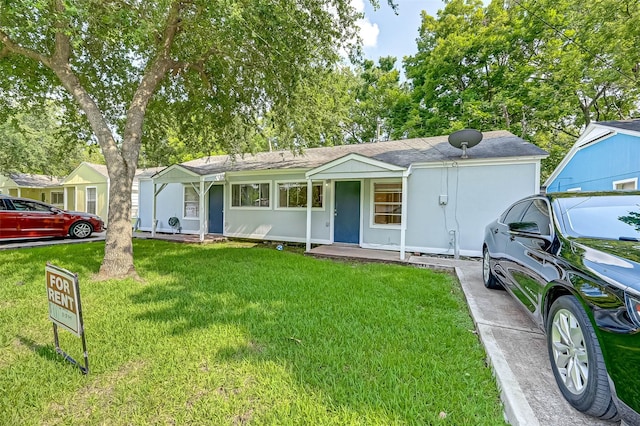 ranch-style house with a front yard and covered porch