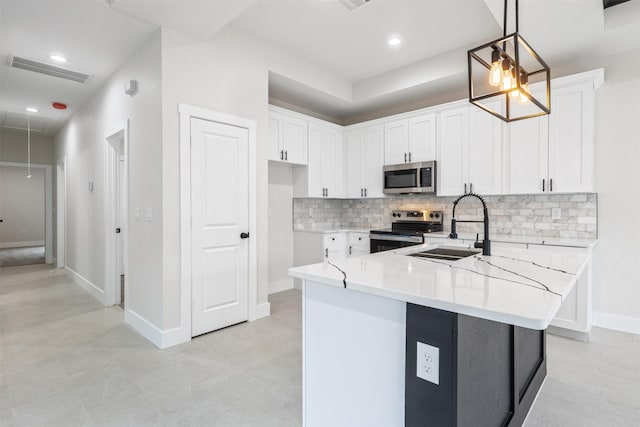 kitchen featuring sink, white cabinets, backsplash, pendant lighting, and appliances with stainless steel finishes