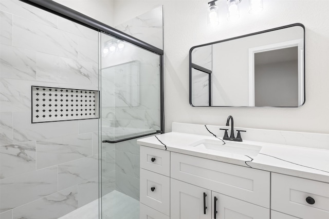 bathroom with a shower with shower door and vanity