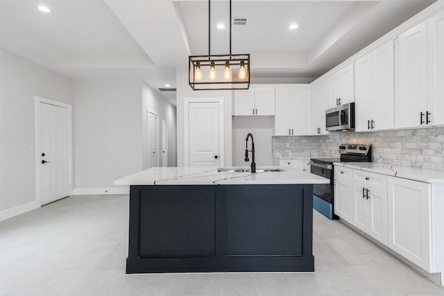 kitchen featuring pendant lighting, a center island with sink, white cabinetry, appliances with stainless steel finishes, and sink