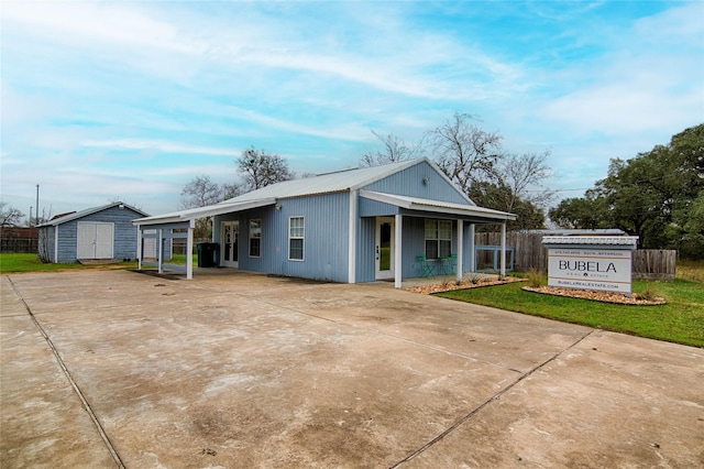 rear view of property with a yard, a carport, and a shed